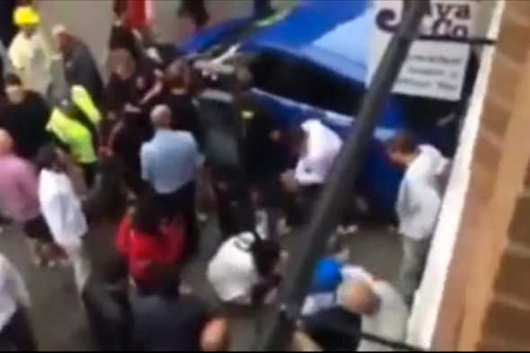 Passers-by help lift car off trapped cyclist