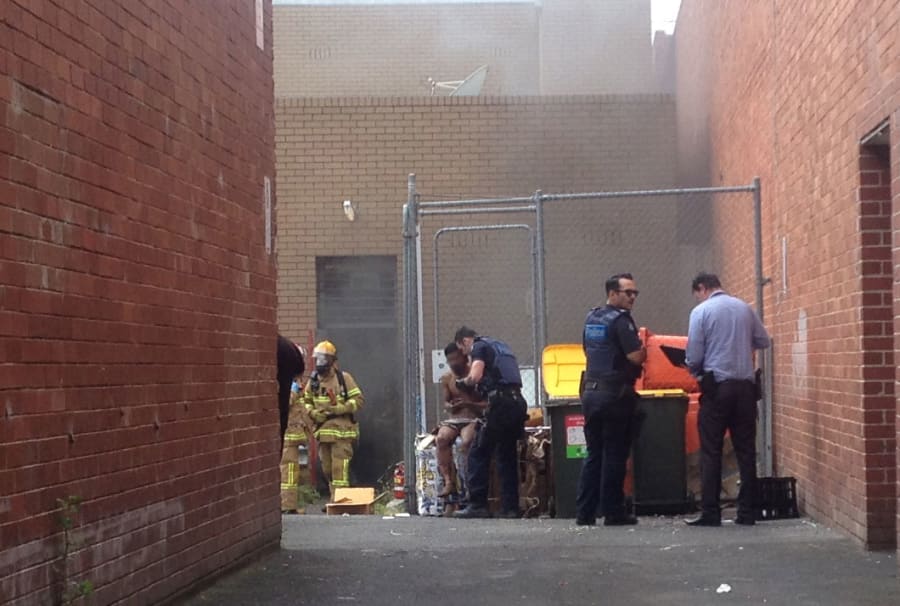 Police speak with a man out the back of the Commonwealth bank branch on Friday