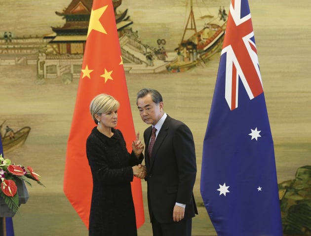 Australian Foreign Minister Julie Bishop shakes hands with Chinese Foreign Minister Wang Yi during their joint press conference at the Ministry of Foreign Affairs in Beijing Wednesday, Feb. 17, 2016. China's moves to assert its sovereignty claims in the South China Sea were expected to be discussed during a visit by Bishop to Beijing on Wednesday. (Wu Hong/Pool Photo via AP)