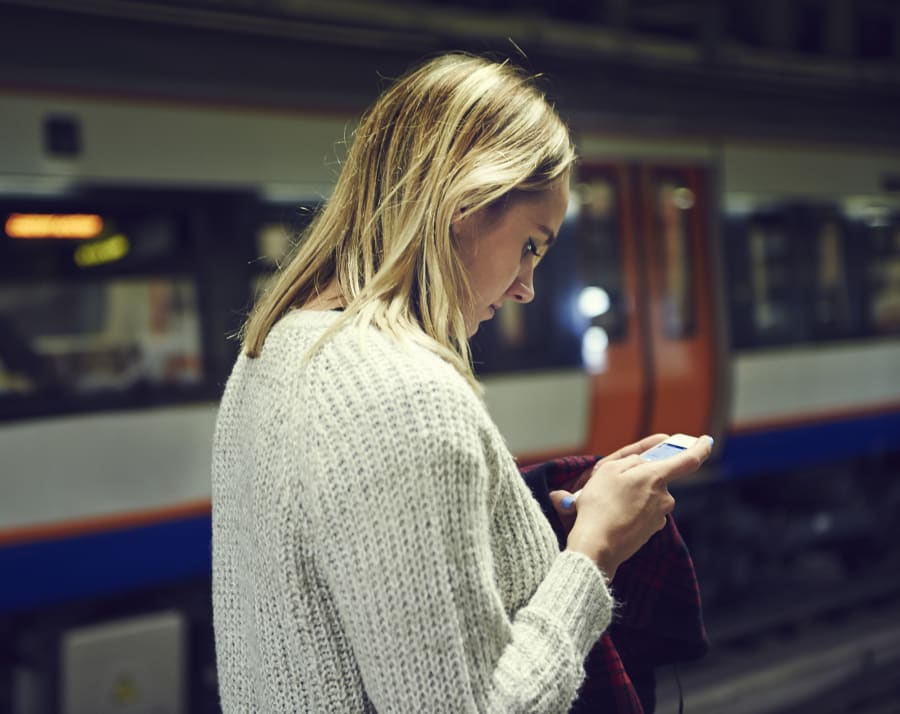 Woman with smart phone in train station