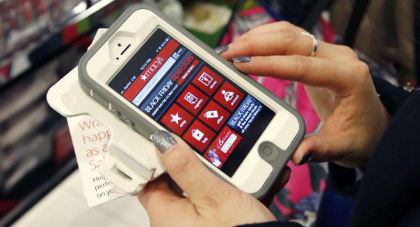 FILE - In this Friday, Nov. 23, 2012, file photo, Tashalee Rodriguez, of Boston, uses a smartphone app while shopping at Macy's in downtown Boston. For the first time, analysts predict more than half of online traffic to retailer sites will come from smartphones than desktops during the busy Black Friday holiday shopping weekend. And though itï¿½s still a small fraction of online revenue, mobile sales are jumping too. Larger phone sizes, improved retailer apps, more online deals and shoppersï¿½ increasing comfort with shopping online are driving the trend. (AP Photo/Michael Dwyer, File)