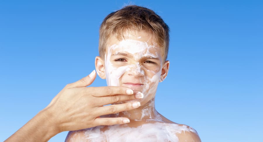 Mother Applying Sunscreen to Son