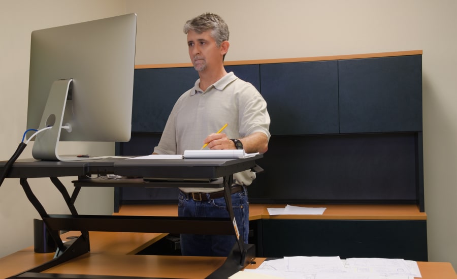 Man using stand up desk in office for good health