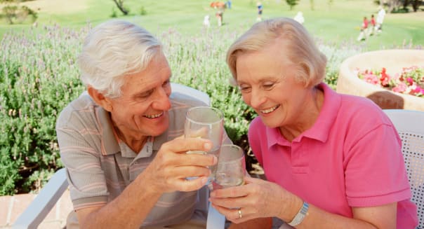 Outdoor portrait of retired couple enjoying a drink at the golf club.