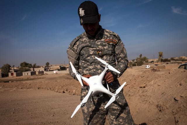 an-iraqi-policeman-holds-a-drone-near-the-village-of-arbid-on-the-picture-id622842840