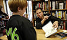 NO INVISIBLE INK, PLEASE: Anthony Horowitz signs a book for 10-year-old Ben Severe at the Politics and Prose bookstore. Ben wears a T-shirt he got for answering an "Alex Rider" trivia question.