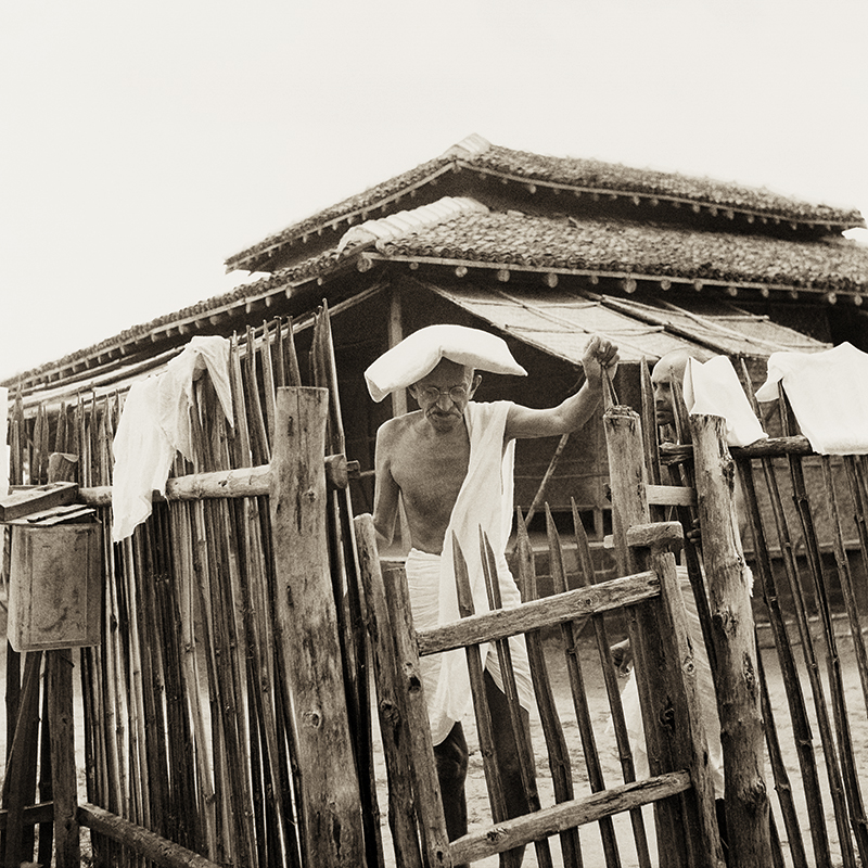 Mahatma Gandhi in front of his office hut, Sevagram Ashram, 1940.