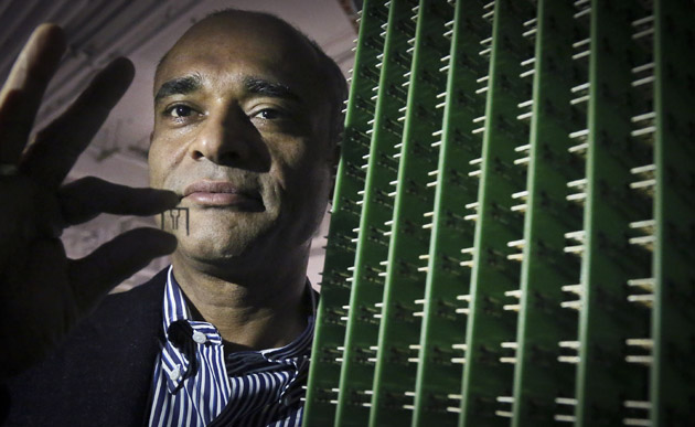 In this Thursday, Dec. 20, 2012, photo, Chet Kanojia, founder and CEO of Aereo, Inc., stands next to a server array of antennas as he holds an antenna between his fingers, in New York.  Aereo is one of several startups created to deliver traditional media over the Internet without licensing agreements. Past efforts have typically been rejected by courts as copyright violations. In Aereoâs case, the judge accepted the companyâs legal reasoning, but with reluctance. (AP Photo/Bebeto Matthews)