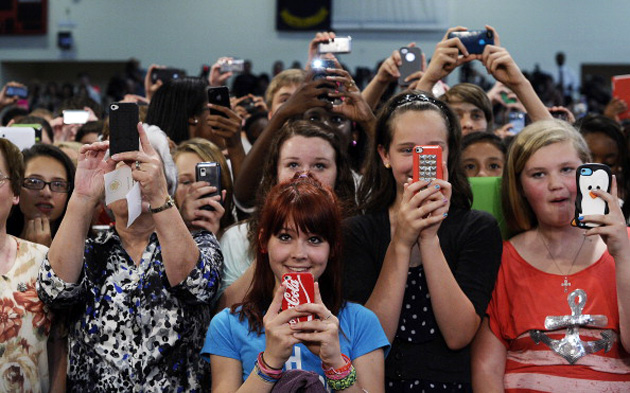 Teachers and students holding up smartphones