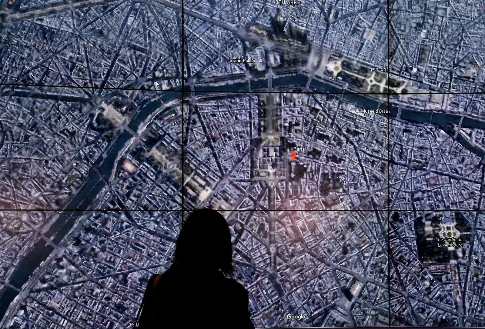 People look at a Google Earth map of Paris,France on a screen as Google Earth unveils the revamped version of the application April 18, 2017 at a event at New York's Whitney Museum of Art.  Google on Tuesday launched a re-imagined version of its free Earth mapping service, weaving in storytelling and artificial intelligence and freeing it from apps. / AFP PHOTO / TIMOTHY A. CLARY        (Photo credit should read TIMOTHY A. CLARY/AFP/Getty Images)