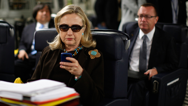 Hillary Clinton checks her BlackBerry