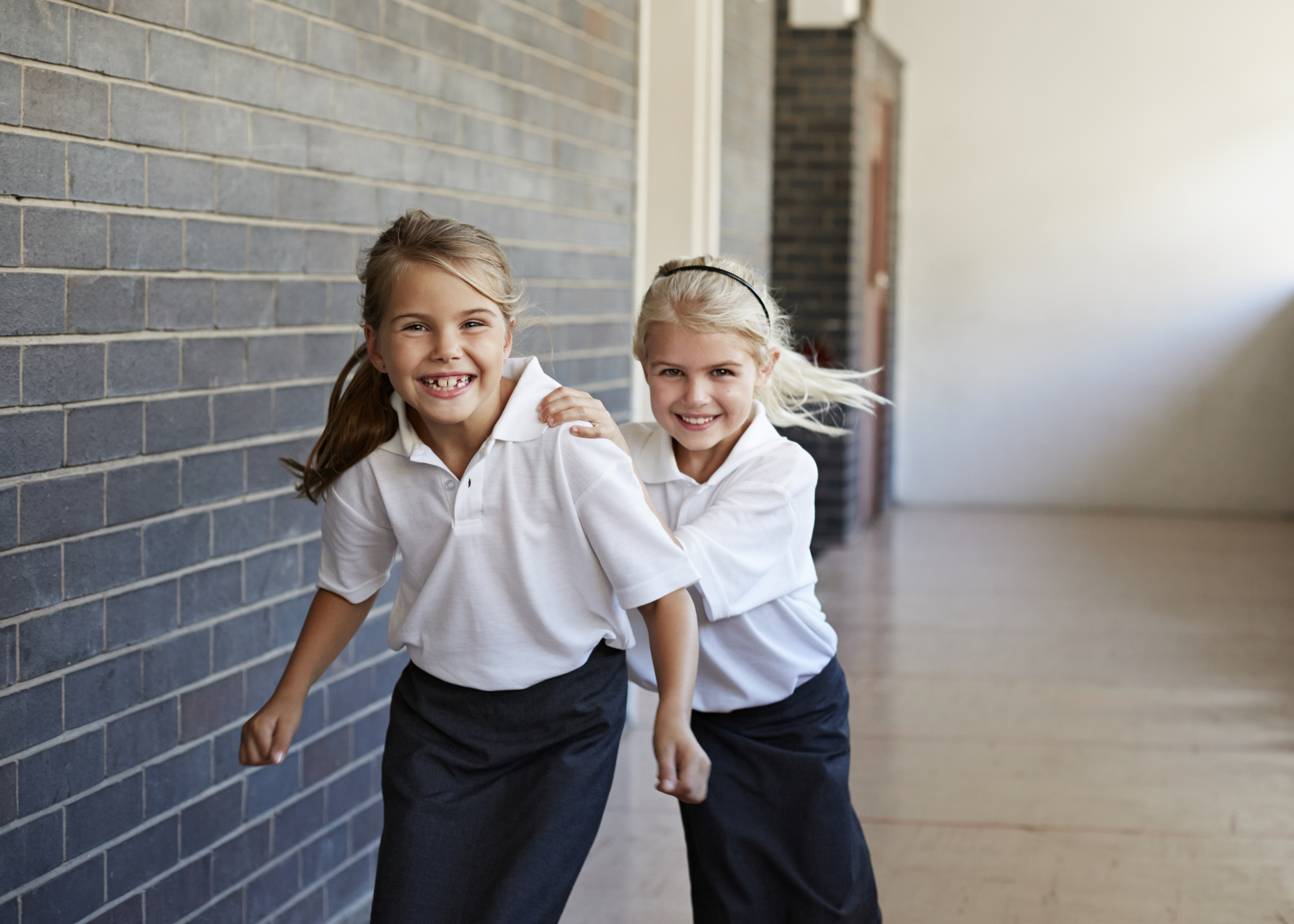 Schoolgirls running &  having fun in a corridor