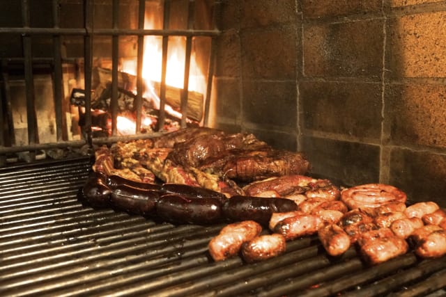 Argentinian barbacue, including all meat and sausages typical form latin america, with fire at the back