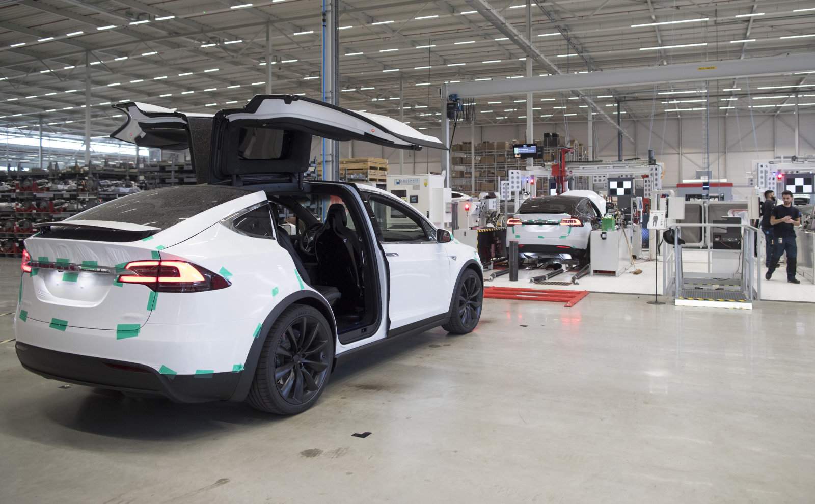 The rear gull wing doors of a Tesla Model X sports utility vehicle (SUV) sit open during assembly for the European market at the Tesla Motors Inc. factory in Tilburg, Netherlands, on Friday, Dec. 9, 2016. A boom in electric vehicles made by the likes of Tesla could erode as much as 10 percent of global gasoline demand by 2035, according to the oil industry consultant Wood Mackenzie Ltd. Photographer: Jasper Juinen/Bloomberg via Getty Images