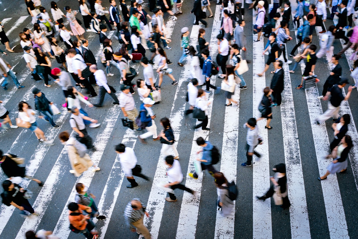 Many people cross the street on a zebra crossing in the Osaka 