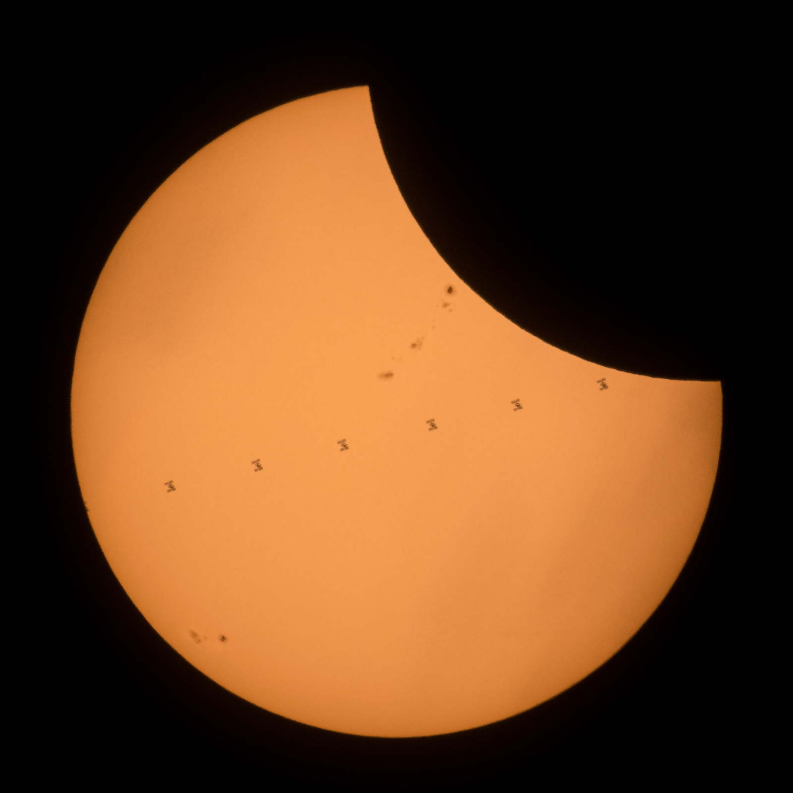 This composite image, made from seven frames, shows the International Space Station, with a crew of six onboard, as it transits the Sun at roughly five miles per second during a partial solar eclipse, Monday, Aug. 21, 2017 near Banner, Wyoming. Onboard as part of Expedition 52 are: NASA astronauts Peggy Whitson, Jack Fischer, and Randy Bresnik; Russian cosmonauts Fyodor Yurchikhin and Sergey Ryazanskiy; and ESA (European Space Agency) astronaut Paolo Nespoli. A total solar eclipse swept across a narrow portion of the contiguous United States from Lincoln Beach, Oregon to Charleston, South Carolina. A partial solar eclipse was visible across the entire North American continent along with parts of South America, Africa, and Europe.  Photo Credit: (NASA/Joel Kowsky)