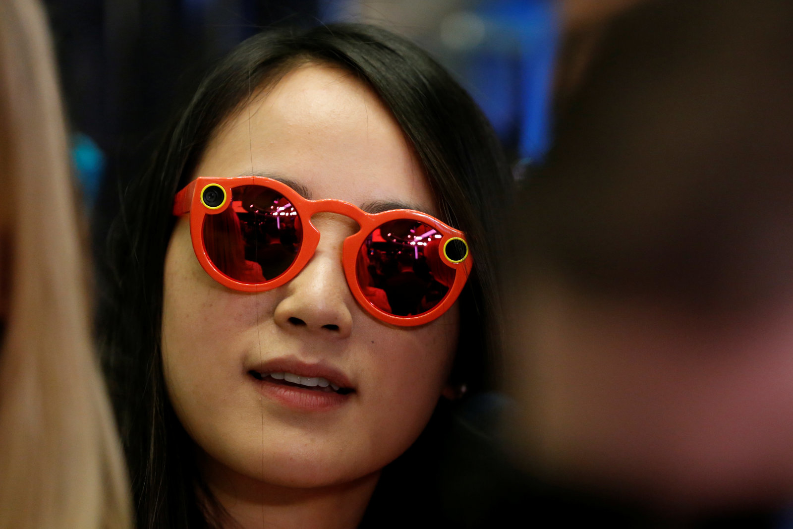 A woman wears Snapchat Spectacles on the floor of the New York Stock Exchange (NYSE) while waiting for Snap Inc. to list their IPO in New York, U.S., March 2, 2017.  REUTERS/Lucas Jackson