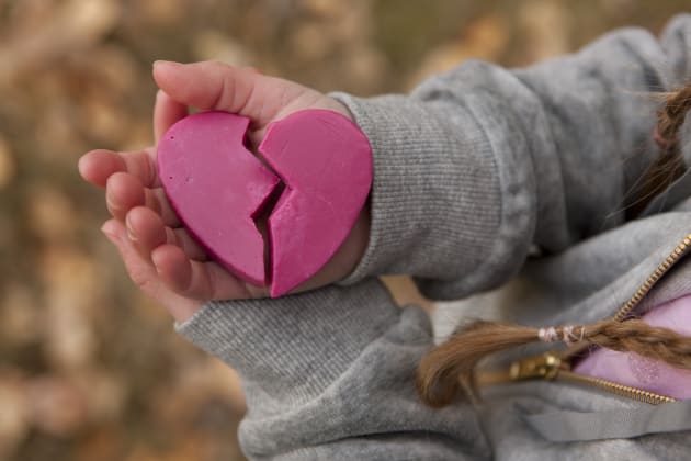 Girl holding broken heart