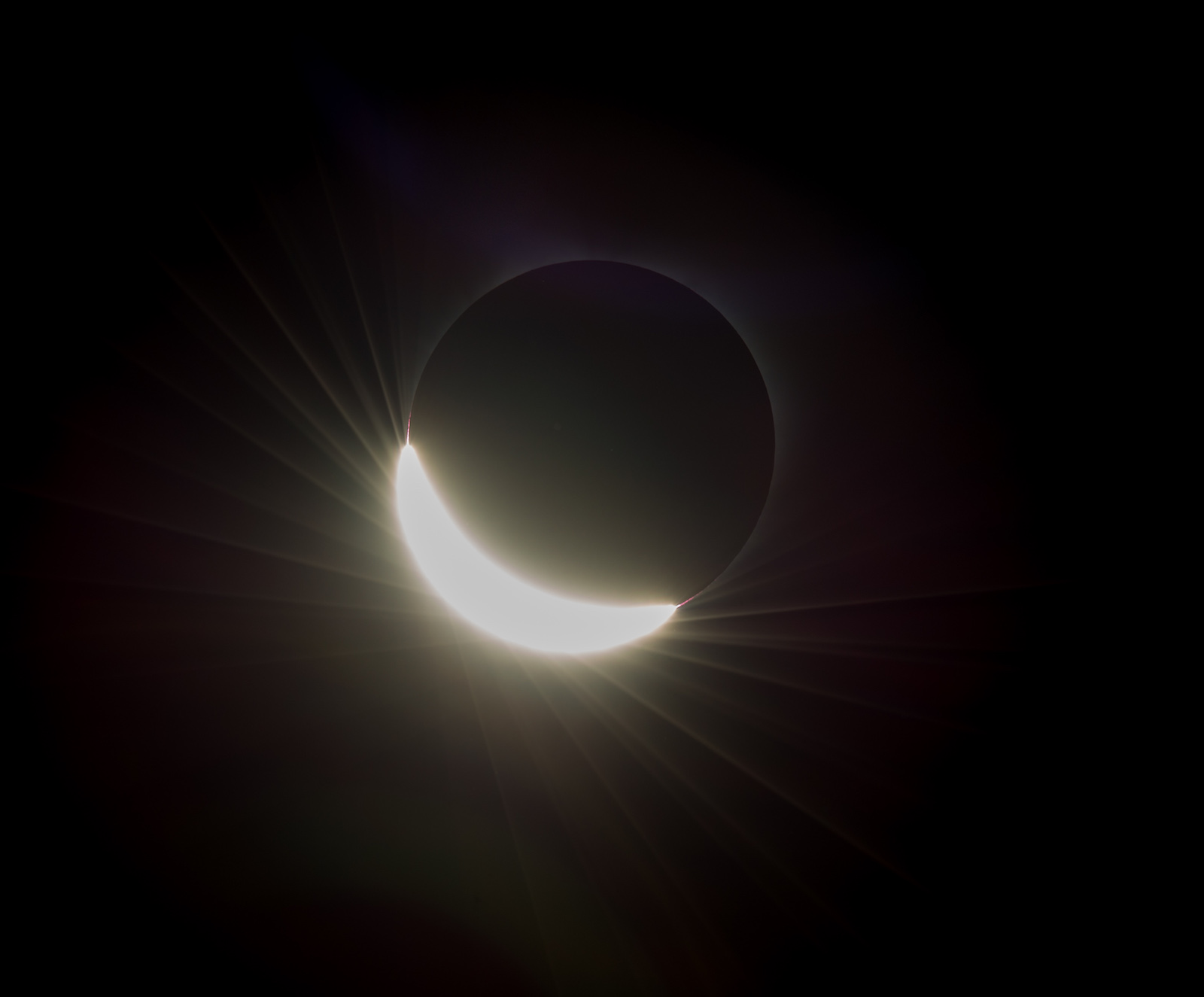 The last glimmer of the sun is seen as the moon makes its final move over the sun during the total solar eclipse on Monday, August 21, 2017 above Madras, Oregon. A total solar eclipse swept across a narrow portion of the contiguous United States from Lincoln Beach, Oregon to Charleston, South Carolina. A partial solar eclipse was visible across the entire North American continent along with parts of South America, Africa, and Europe.  Photo Credit: (NASA/Aubrey Gemignani)