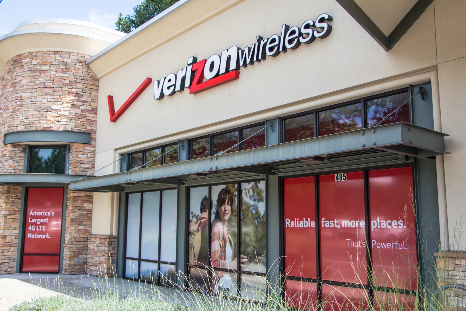 Eugene, Oregon, USA - July 8, 2014: Verizon Wireless Store location in Eugene, Oregon. Verizon sells cell phone services as well as cable across the United States with more than a 1000 locations.  This is a picture of Verizon's advertising on the side of the building as vehicles pass by.