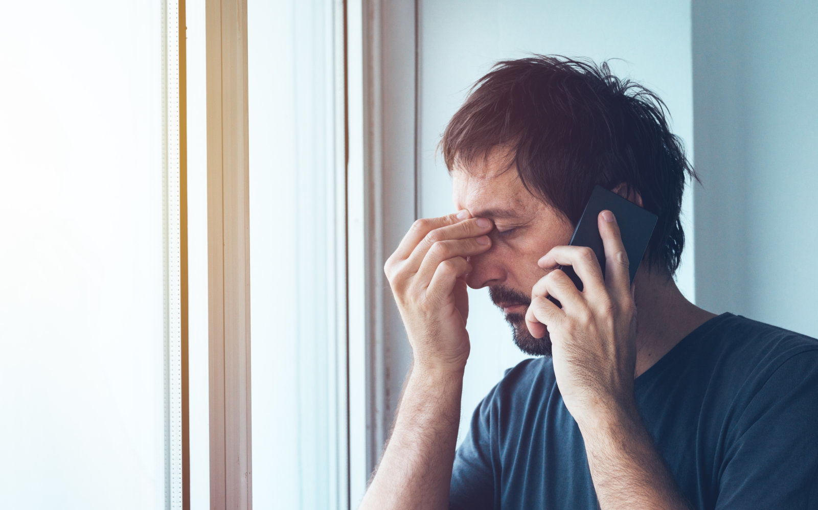 Unpleasant phone call, worried anxious man talking with someone on mobile phone
