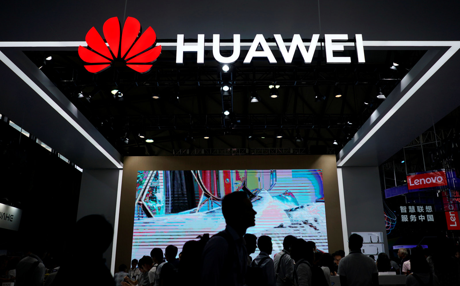 People walk past a sign board of Huawei at CES (Consumer Electronics Show) Asia 2018 in Shanghai, China June 14, 2018. REUTERS/Aly Song