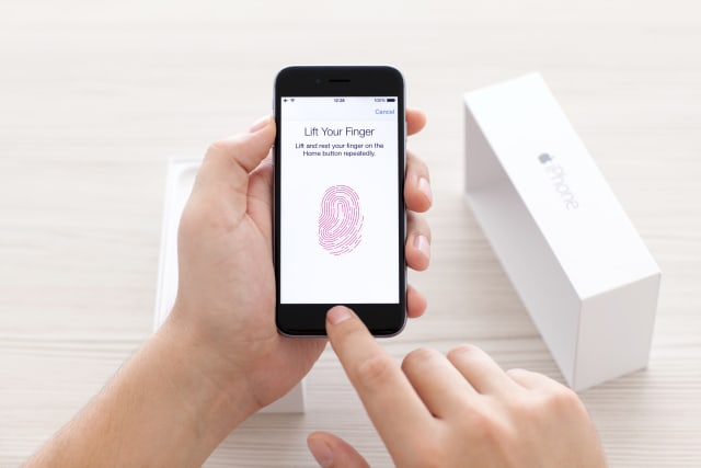 Man scans the fingerprint sensor Touch ID on iPhone 6