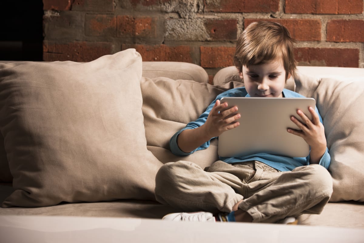 Boy sitting with digital tablet