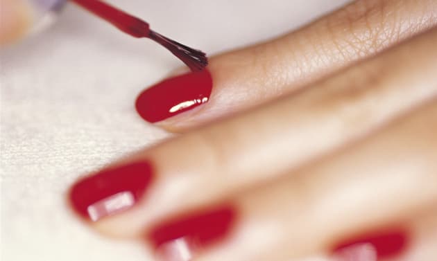 Close-up studio shot of woman applying nail polish