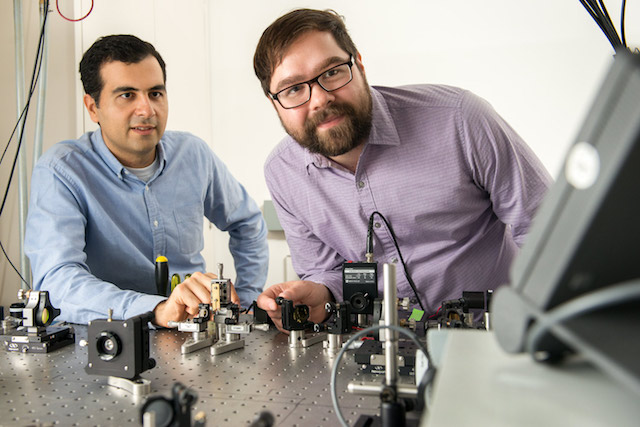 Alireza Marandi and Marc Jankowski with their experiment at the optical bench.