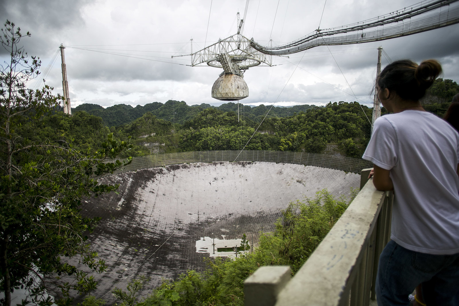 A visitor views the world's largest single dish radio telescope at the Arecibo Observatory in Arecibo, Puerto Rico, on Friday, Aug. 25, 2017. Over the years,Â Puerto RicoÂ has wooed visitors and investors with beaches, sun, tax breaks and splashy public works. Now the Caribbean island wants to add an outpost of Chinese culture, complete with graceful pavilions and regional cuisine. Photographer: Xavier Garcia/Bloomberg via Getty Images