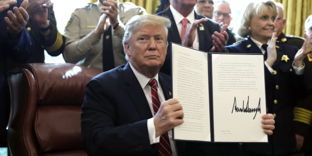 Donald Trump sostiene la carpeta con los documentos de su primer veto, hoy, en la Casa Blanca. 