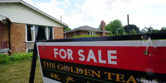 A "for sale" sign is pictured in front of a house in Toronto, July 17, 2018. Interest rates in Canada could fall this year if the global economy is unstable, Central 1 Credit Union predicts.