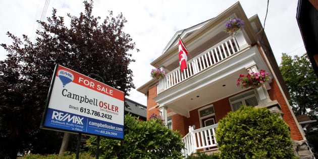 A real estate sign is seen in front of a house for sale in Ottawa, Aug. 15, 2017. 
