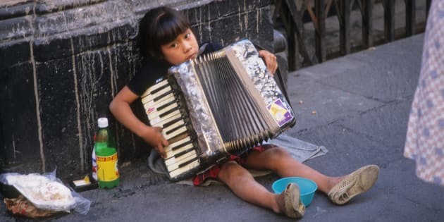 CHILD BUSKING IN STREET, MEXICO. Mexico City. Girl playing the accordion to tourists for money. CDREF00273