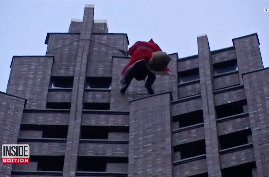 Santa surprises children by repelling down skyscraper to deliver gifts ...