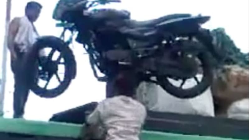 Watch this Indian man carry a motorcycle up a ladder on his head
