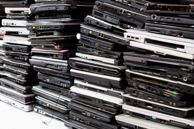 Stack of old, broken and obsolete laptop computers