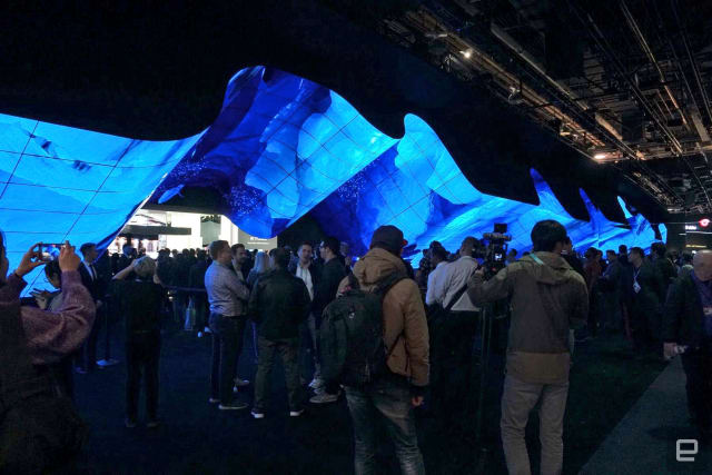 An image from the show floor at CES showing a great 'wave' of curved oled tvs.
