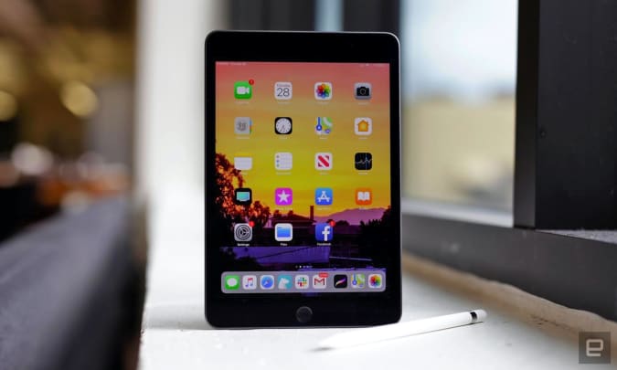 The Apple iPad mini and stylus sit on an office window sill.