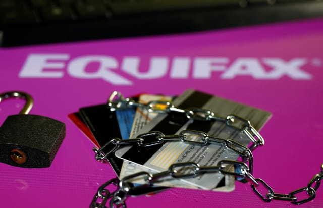Credit cards, a chain and an open padlock is seen in front of displayed Equifax logo in this illustration taken September 8, 2017. REUTERS/Dado Ruvic/Illutration