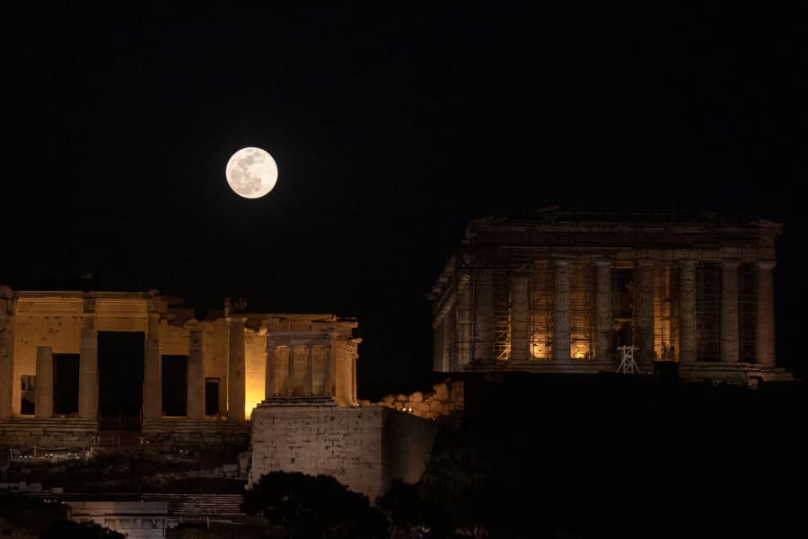 Una súper luna de nieve se ve sobre el sitio arqueológico de la Acrópolis en Atenas, Grecia.