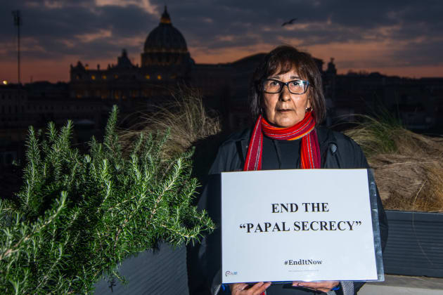 Evelyn Korkmaz, a victim from Canada, holds a sign with her message to Pope Francis on Feb. 18, 2019,...