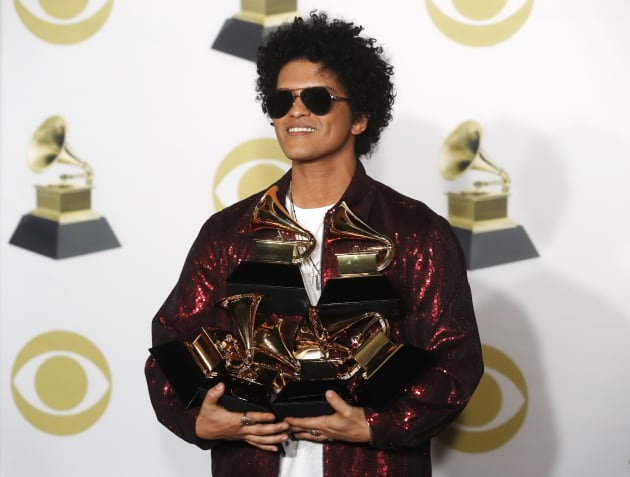 Bruno Mars sosteniendo sus seis Grammys