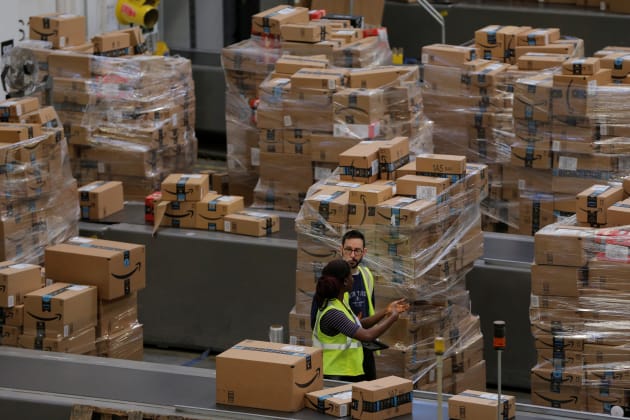 Trabajadores apilan cajas para ser enviadas dentro de un centro de entrega de Amazon en Robbinsville, Nueva Jersey.