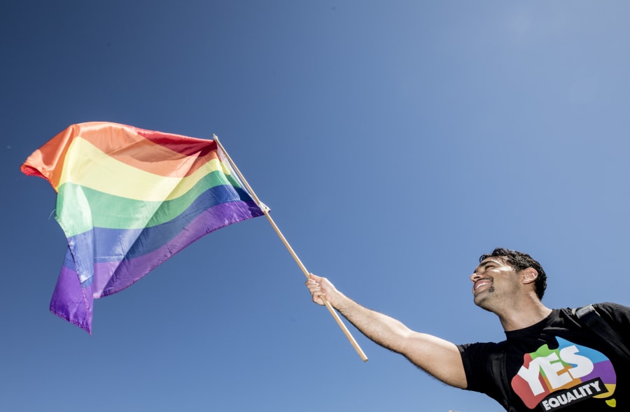 Sydney, Australia -- November 15: A man proudly waves the LGBTQ Pride Flag. 