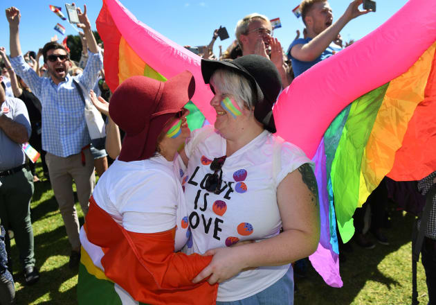 A couple embrace as supporters of the same-sex marriage 'Yes' vote celebrate the announcement in a Sydney park on November 15, 2017.