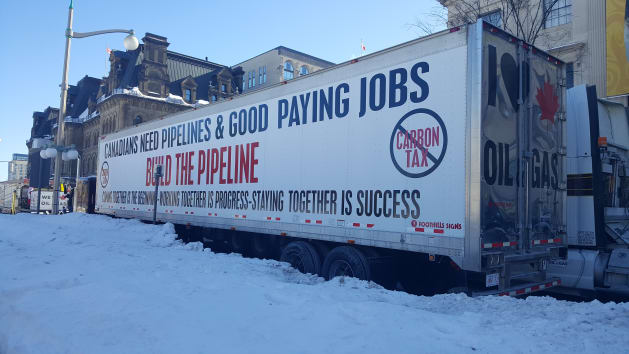 A convoy truck touches a pro-pipeline message outside the Senate round in Ottawa on February 19,