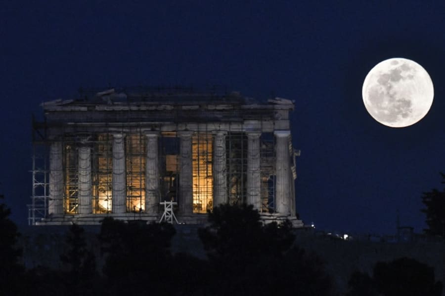 La Súper Luna de Nieve se levanta junto al Templo del Partenón en el sitio arqueológico de la Acrópolis en Atenas, Grecia.