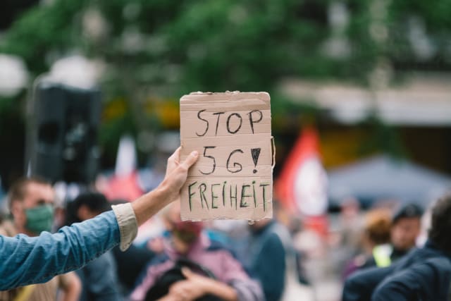 A placard ''Stop 5G freedom'' is seen during the rally against coronavirus policy in Cologne, Germany, on May 16, 2020. (Photo by Ying Tang/NurPhoto via Getty Images)